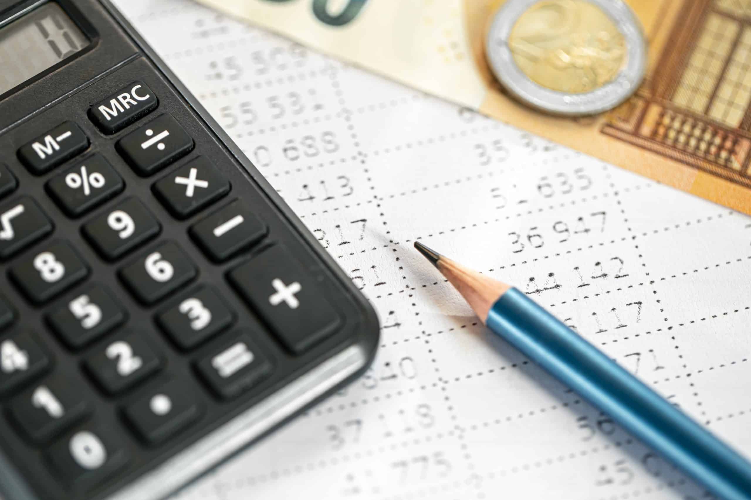 Calculator, money and pencil close-up on a blurred background. Chart of accounts set up in Spokane WA